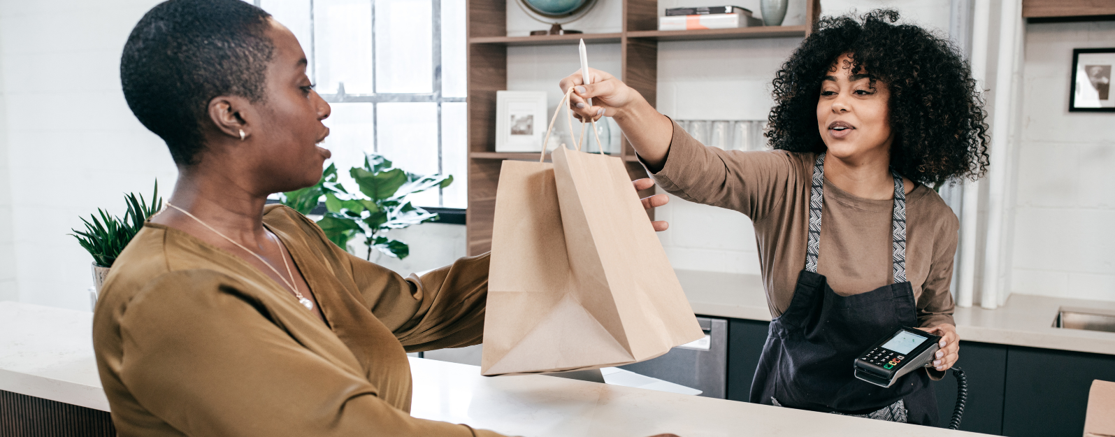 store employee handing a customer their bag at checkout