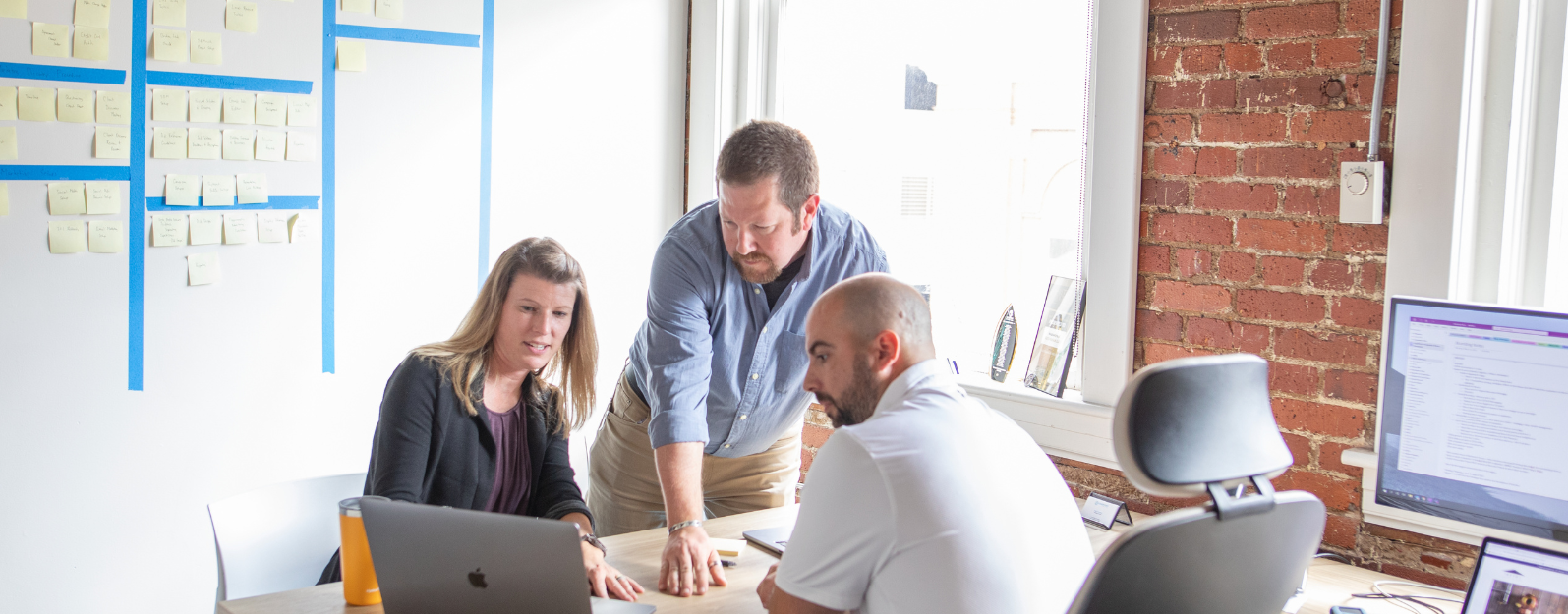 Carrie, Matt, and Brad looking at a laptop